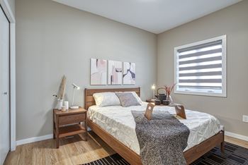 A bedroom with a bed, nightstand, and lamp.